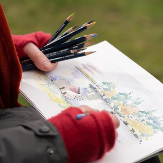 Person tegner med Derwent Watercolour Pencils på akvarelpapir.